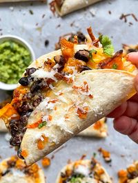 These baked butternut squash tacos have a mix of seasoned butternut squash, seasoned black beans, and shredded cheese.