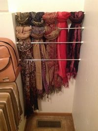 Making use of wasted space inside my closet. Easy scarf storage using several tension rods. by patty