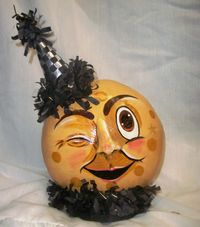 2013 Winking Harvest Moon - created from dried canteen gourd and accented with fabric covered paper mache hat and tissue festooning. by Carolyn Lockwood - Hebron, OH