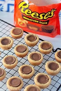 Everyone loves these Peanut Butter Cookie Cups! Peanut butter sugar cookie dough baked into bite-sized cups and filled with a Reese's Peanut Butter Cup--so much flavor in every little cookie cup. #reeses #peanutbutter #peanutbuttercups #reesescups #peanutbuttercookies #cookies #cookiecups