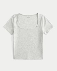 A cozy and super soft short-sleeve baby tee in ribbed fabric. Square neckline, short sleeves. Slim Fit.This item is available in extended lengths:Short - 17"Regular - 19"Long - 21"