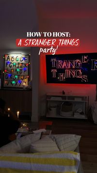 How to host a Stranger Things theme party:  • Create the alphabet lights either on a wall or canvas by adding vintage wallpaper as the background then cutting out letters from black paper. Add rainbow bulb string lights.  • Make Stranger Things-inspired cupcakes by piping thin black icing as a light strand and adding M&M’s as the lights.  • For other food, opt for a DIY waffle bar & pizza.  • Use a vintage phone as a decor prop!  • Add yellow striped blankets or towels to the couch to provide an 80s feel.  • Add rainbow string lights elsewhere throughout the house!  • Turn a doorframe into Castle Byers by adding a striped sheet over the door, then taping on an American Flag and the Castle Byers signage. To create the signs, I added wooden contact paper to cardboard and then painted over