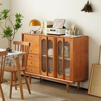 Introducing our Sideboard, a well-designed and functional storage solution that will enhance the organization and style of your space. With its thoughtful layout and various storage compartments, this sideboard is perfect for any home. The sideboard is divided into three storage areas. The left side features a sliding door storage compartment on the upper portion and three drawers on the lower portion. On the right side, you will find a double-layered glass cabinet, creating a functional storage