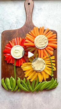 Cheese, Charcuterie, Fun Food Boards & MORE on Instagram: "•HUMMUS & VEGGIE FLOWERS•  How cute are these VEGGIE flowers??!! Perfect for Easter or any springtime gathering! 🌺🌼🌺  I used red/yellow bell peppers and carrots for the petals. Green onions for the stems, and sugar snap peas for the grass. I then added little bowls of flavored hummus and whipped feta to dip!  Healthy, delicious, & adorable is my favorite combo! 🥕😍🌺🫛🫑😋  #veggieflowers #veggietray #veggiegarden #eatyourcolors #eastertable #springtimevibes #springflowers #springgarden #funfood #funfoodideas #foodart #todayfood #bhgfood #foodvideos #foodstyling #seecandycook"