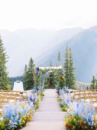 A whimsical chuppah at The Little Nell in Aspen, Colorado, We loved these colorful wedding florals all throughout their day. The mountains are the best wedding ceremony backdrop. Wedding by By Bello Events.