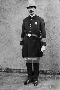 American Gilded Age era, c.1900. A New York City policeman in uniform with badge, and the insignia of the New York State seal on his hard hat, c.1900. ~ {cwl} ~~ (Getty Images)