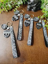 Skull, Spiderweb, and Roses Themed Gothic Bridesmaids Keychains, "Bride, Maid/Matron of Honor, and/or Bridesmaid". Perfect for Bridesmaid Proposal boxes, Bridal or Bachelorette gifts, Bridesmaid Thank you Gifts, or as a unique gift for Bride! Price listed is for one keychain not the set but includes free personalization Choose which keychain you would like and provide names in the personalized box.  Each Skull keychain is hand poured black epoxy resin that has cured for 48 hours or more. They ha