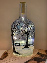 In The Bleak Midwinter is hand painted with acrylic paint on a whiskey bottle. It includes a 6 string of fairy lights and cork. (AA battery not included) The bottle I use for this is a wonderfully heavy bottle from a local distillery (Caledonia Distillery) who save me their empties from their