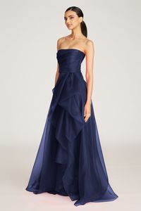 Our bestselling Teresa gown is back in a navy colorway. It's sculpted in pebble organza — a weightless and high-quality fabric woven to give your style movement and bounce. This radiant piece comes strapless and features a draped bodice, front slit accent, and a cascading ruffled skirt. Click here for all available colors. Strapless Neckline A Line Silhouette Non-Stretch Floor Length REF: 8817572