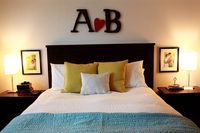 Spouses initials above headboard with heart in between. And small wedding pictures above the nightstand.