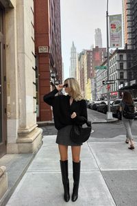 @fredrika_ekerot is wearing Sézane Emile oversize black knit cardigan and Amandine black knee high boots. The short grey skirt and black leather bag are personal pieces.