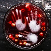 Here's what you need: lychees in syrup, blueberries, red food coloring, cranberry juice, ginger ale, reserved lychee juice, vodka, food-safe glove