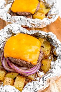 Seasoned hamburger patties are baked up tender and juicy with Yukon Gold potatoes, red onions, and sliced Cheddar. An easy foil dinner idea!