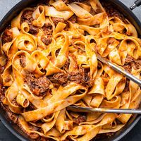 Beef short ribs are braised in a tomato red wine sauce with fresh thyme until the meat falls off the bone and tossed with pappardelle ribbons and plenty of Parmigiano Reggiano cheese.