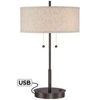 Equipped with a USB port and an outlet utility plug on its base, this slim, bronze finish transitional metal table lamp is fit for the modern era.