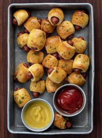 Pigs in a Blanket Recipe is cocktail-sized sausages wrapped in strips of a crescent roll dough, baked to a golden brown, and brushed with garlic butter. It's the perfect finger food to serve at your Christmas party!