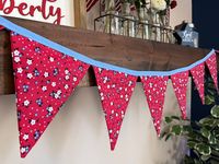 Handmade bunting banners add fun and color to any occasion or celebration and are so classic!  This banner is perfect to decorate your kitchen, dining room, mantel, coffee bar, or window for Memorial Day, July 4th or any time of the year.  This banner would also be great as part of a photo backdrop.   This banner is made from 100% cotton fabric.  The fabric is a pretty floral with a red background and little white and blue flowers scattered about.   Each double sided flag measures approximately 5x6 inches and they are connected by a coordinating blue binding.  There are 8 flags in the banner pictured. This banner measures approximately 60 inches long in total with about 10 inches at each end for hanging your banner.   Additional lengths are available. This banner is meant for indoor use as