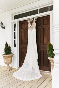 Wedding dress hanging up on doors for Faith's wedding day . Grace Valley Farms is a beautiful southern wedding venue with a large property & a ton of beautiful photo worthy spots. This room in the bridal suite home is super moody & provides a beautiful backdrop for wedding detail photography   open back wedding dress, wedding photos , wedding photo ideas , wedding photography , wedding dress photos , wedding photo must have , wedding shots , detail photography , wedding photographer , tennessee photographer , Nashville photographer , Murfreesboro photographer , Tennessee portrait photographer , tennessee wedding , southern wedding , country wedd