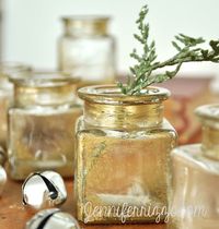 Easy DIY gold antiqued glass with spray paint! Use recycled bottles and upcycle them with a pretty aged gold mercury glass look!