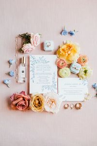 pastel lay flat detail flowers; pink, white and dusty blue, pale blue, yellow flowers; From the outset, they envisioned a celebration that embraced the natural beauty of a garden wedding flowers setting, with blooms that echoed the colors of a bright summer day.