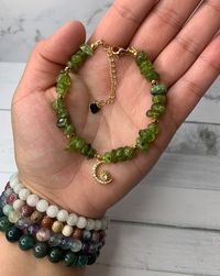 Welcome to my shop! 🦋 If you love handmade genuine crystal jewelry, you are at the right place!  This gorgeous green peridot crystal bracelet is a handmade piece with 6-8mm peridot crystal chips, 3mm gold-plated spacer beads, a gold-plated crescent moon charm, and an 18K gold-filled 2inch extender.  This bracelet is approx. 6 1/2 inches in length with an 18K gold-filled 2inch extender.  Every piece is made to order and usually takes 5-7 business days for production and 1-2 business days to ship.   Every piece is unique due to each stone being slightly different. All beads are genuine crystals.  Each piece is handcrafted with love ♡︎  For best care, keep jewelry pieces dry at all times. All sales are final. No exchange or returns.    Any questions feel free to message me and I will respond