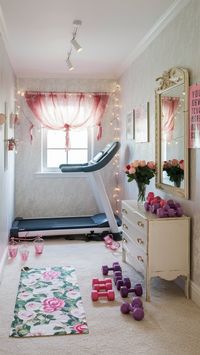 Design a chic floral fitness nook for a stylish workout! 🌸 This charming space features floral-patterned wallpaper, cream carpet, and a sleek white treadmill. A floral yoga mat and vintage white dresser hold pink and purple dumbbells and fresh roses. Fairy lights and motivational posters complete the serene, whimsical look. ✨ #StylishGym #FloralFitness