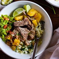 Slow cooker pineapple pork shoulder served over cilantro lime cauliflower "rice" & topped with fresh guacamole. Gluten & Dairy Free.