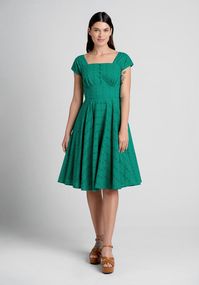 It doesn’t get more 1950’s vintage-inspired than this emerald green fit-and-flare dress from Timeless London. Made from a lightweight cotton weave, fully-lined with a stunning overlay that boasts a broderie anglaise eyelet design, this swing dress boasts a square neckline with delicate shirring along the bust, shirred cap sleeves, a corset-inspired bodice with decorative front buttons at the front, and an ample flare skirt with handy side pockets.