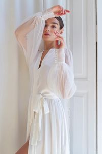 Long bridal robe  will be the perfect addition to your wedding look. Made of sheer pleated fabric, it gives the impression of elegance and tenderness. Long bridal robe has a fitted style emphasizing the feminine curves of the body, as well as comfortable sleeves made of the same transparent pleated fabric, which add some mystery and sophistication. White wedding robe pleated The wedding kimono robe is decorated with pearl jewelry, which adds tenderness and luxury. It makes this dressing gown even more attractive and attractive for the bride. Long silk satin robe Also, this robe can be a wonderful gift for bridesmaids. It will highlight their role in your wedding and also make them feel special and unique. Bride robe for wedding robe Don't forget to add this bridal gown to your bridal acces