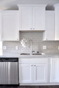 Smoke Gray glass subway tile, white shaker cabinets, pull down faucet - gorgeous contemporary kitchen