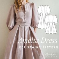 The Amelia dress pattern is an intermediate sewing pattern. Amelia is a semi-fitted dress with a fitted bodice. The dress has a waist seam, bust and waist darts on the front, as well as waist darts on the back. The center back seam has an invisible zipper closure. The skirt features pleats at the waist. The dress has a round neckline. The set-in sleeves are 3/4 length, wide and gathered at the cap and bottom. There is a cuff at the bottom of the sleeves. Dress A is embellished with an embroidere