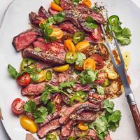 Cutting the steak immediately after cooking breaks all the rules on meat cookery, but in this recipe we do it intentionally in order to capture the juices and incorporate them into the dressing. Serve this grilled flank steak recipe with crusty bread to soak up the deliciousness.