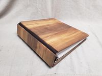 This handcrafted photo album is made from walnut. The walnut in this album was cut from a tree that fell on our family farm. This part of the wood has a lot of the sap in it, which is what gives the walnut that light colored look compared to the normal, dark brown look that walnut usually has. This and all my albums are made the same as a standard 3-ring binder. It has 60 pages to hold all your favorite pictures. Each page will hold 1 8x10 or several smaller pictures. The hinges are made from real leather, so this album will last a lifetime. The 3-ring binder is 1 & 1/2 inches. The wood part measures about 12 x 11 x 2 1/4 inches. This is an album you'll be proud to set out on the coffee table. Don't hide your photos in the closet or on your phone. Share them with all your friends and famil