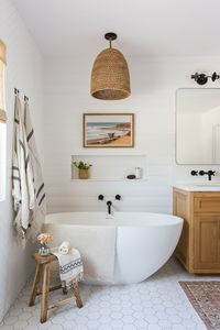 A large and spacious master bathroom with light wood, white tile, and a great tub. #homedecor #bathtub #freestandingtub #coastalstyle