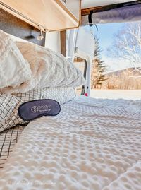 RV Bed with Open Back Door Looking at Mountains.