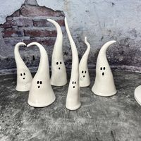 "Handmade spooky ghosts for Halloween decorating. Add some haunting spirits to your decor with these mischievous ghosts. Varied sizes, heights and widths, and assorted facial features give you plenty of choices to create the perfect tabletop scenario.  Each white ghost has eyes and mouth in black. Heights range from 5\" to 7\"  Please convo to request a possible shipping adjustment if more than one ghost is purchased.   All ghosts are handmade of stoneware clay and kiln fired for durability. The