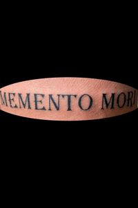 Memento Mori script in black font.