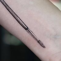 Micro-realistic paintbrush tattoo located on the inner