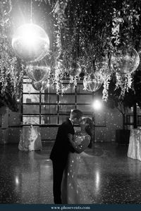 The bride and groom share a magical kiss under our epic disco ball hanging instillation. Can we talk about that sparkle that adds such a magical touch to this wedding. Gorgeous! To see more from our lighting collection, click the link in the pin and check out our website. #2023weddingtrends #weddingtrends #discoballs #weddingreceptiondecoration