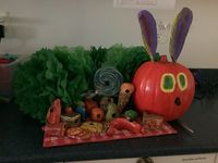 Ready for our school pumpkin competition. We molded the food out of clay, then painted it to look like the book. The pumpkin was painted with modge podge first, then painted to match the color of the caterpillar. We used pom poms for the body and hot glued it all together.