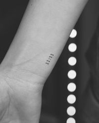 Tattoo of the angel number "11:11" located on the