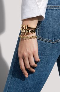 “Always find that balance,” stylist Vanessa Traina says of mixing graphic gold bracelets with a button-down and blue jeans. “It is classic yet modern with an edge…it makes a statement that is both bold and at ease.”