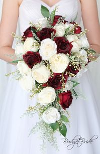 This cascading brides’ bouquet is the perfect option if you have chosen burgundy or ivory as one of the accent colors for your wedding. A lovely array of roses in burgundy and ivory and ivory berries. Lush green foliage polishes off this romantic, natural design. As always, this bouquet has been wired by hand and designed by our in-house florists - you can rest assured that our bouquets will maintain their quality and stand the test of time for years to come. We never use foam to anchor our flow