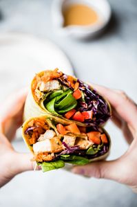 Bright, fresh crunchy rainbow Thai peanut chicken wraps packed with veggies like red cabbage, carrot, spinach and red bell pepper. These easy Thai peanut chicken wraps are protein-packed and have a delicious, flavorful peanut dressing for drizzling and dipping. The perfect lunch that's easily made vegetarian or vegan! #lunch #wrap #chicken #mealprep #healthylunch #dairyfree