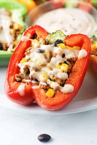 Chipotle Turkey Stuffed Peppers - Deliciously protein packed bell peppers, stuffed with lean ground turkey, black beans, corn and topped with a chipotle drizzle. Low carb, gluten free and delicious! www.itscheatdayeveryday.com