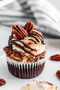 These Turtle Chocolate Cupcakes feature a moist and fudgy chocolate cupcake that’s filled with pecan caramel sauce and topped with the most heavenly caramel cream cheese frosting! Multiple easy recipes come together to create cupcake perfection! | queensleeappetit.com #cupcakes #creamcheesefrosting #chocolatecupcakes