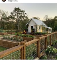 homestead with raised garden beds and a greenhouse