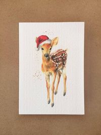 A sweet deer Christmas card printed from original artwork, an adorable fawn in a santa hat ♥ Cute animal cards are perfect for Christmas, you can't help but smile back at that little face! A lovely handmade greetings card makes giving much more special ☺♥ My original fawn painting is printed on thick textured watercolour paper ♥ Blank on the inside for your own message♥ Give a little arty gift too - The A6 card can also be framed as a 'mini print' Please visit my shop for more designs ☺www.etsy.