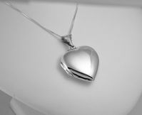 "This lovely sterling silver heart shaped locket measures 1\" long and about 1\" wide, with a high polish finish on both the front and back. This one is more rounded, or domed, rather than flat, so it is about 1/4\" thick and nice and sturdy (and also hard to get a good photo of!) An 18\" sterling silver box chain with a spring ring clasp is included with this locket. This beauty opens to reveal space for two cherished photographs! The photo holders are about 7/8\" long by 7/8\" wide. These look