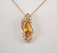 Yellow Gold Yellow Sapphire and Diamond Pendant with Chain. This gorgeous pendant is set in the center with a Pear Shaped Yellow Sapphire. This Sapphire is 100% Natural, measures 7 X 5 mm and weighs 3/4 carat.  There are also twenty-four Round Brilliant Diamonds and six Baguette Diamonds set throughout this pendant. These diamonds are H color, SI/I clarity and weigh a total of .20 carat. This pendant is 10K Yellow Gold and comes with an 18" 10K Yellow Gold chain and together weigh 2.0 grams. Thi